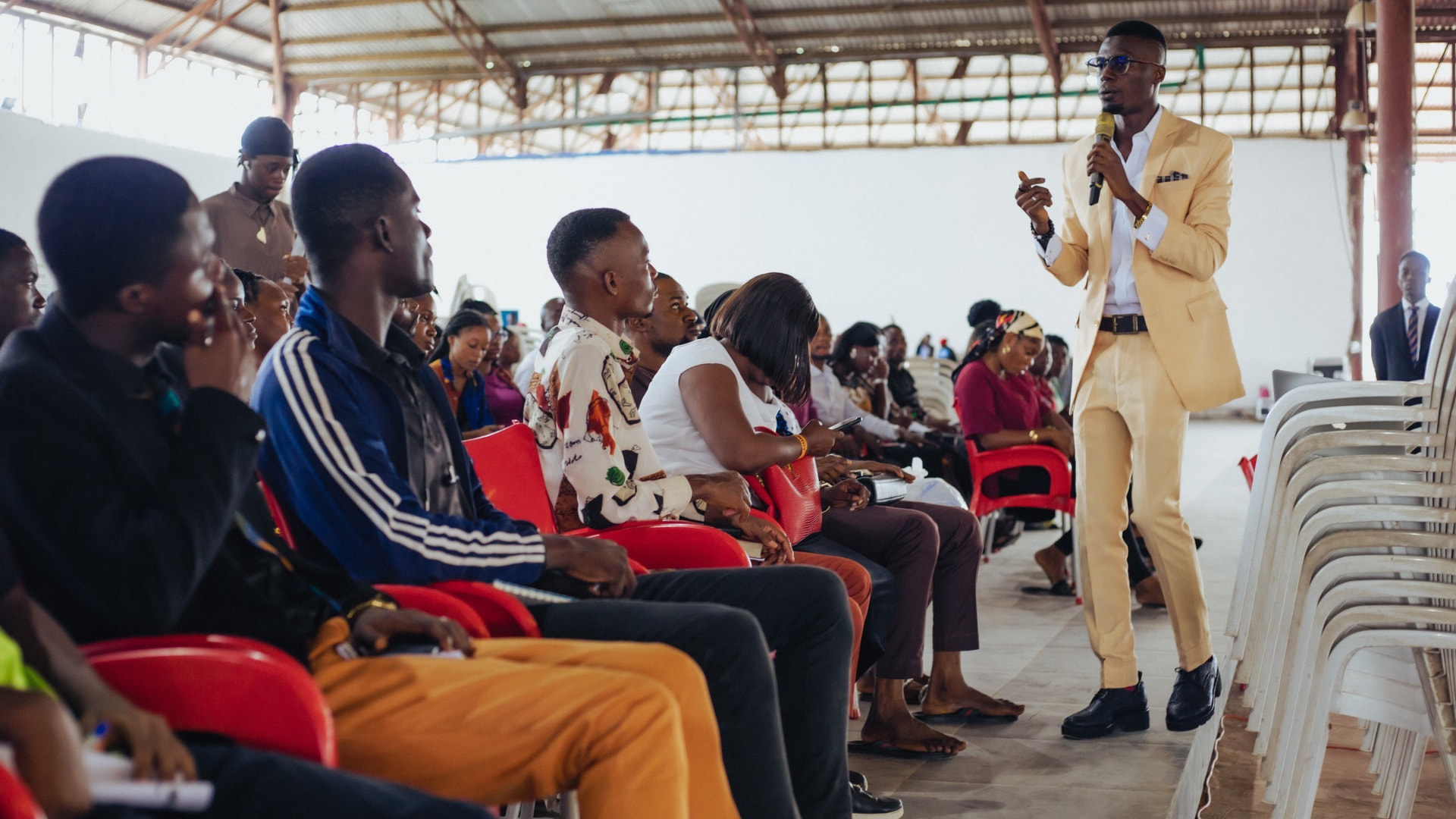 Prince Oluwatosin Odumosu speaking on stage to a seated audience